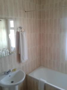 y baño con lavamanos, bañera y lavamanos. en Hostal Europa, en Estepona