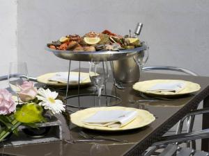 a table with a plate of food on a table at Locations de Vacances Le Clos Rhea in Saint-Martin-de-Ré