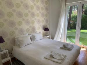 ein Schlafzimmer mit einem Bett mit Handtüchern darauf in der Unterkunft Aroeira Villa near Lisbon- Daydream PT in Charneca + 38 Fotos