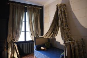a bedroom with a bed and a window with curtains at La Closerie Saint Jacques in Loches