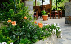 un giardino con fiori di arancio e bianco su un patio di Athina a Rethymno