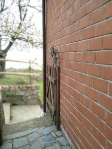 a brick wall with a bird on a fence at Tra er Boscu er Maa in Volastra
