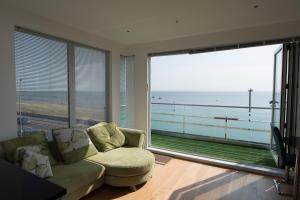 sala de estar con sofá y vistas al océano en The Estuary View, en Thorpe Bay