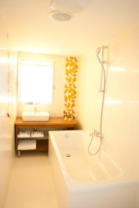 a white bathroom with a tub and a sink at Grand Hotel in Târgu-Mureş