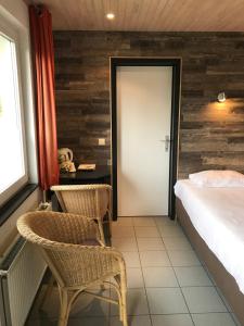 a bedroom with a bed and two chairs and a door at Camping village SY in Ferrières