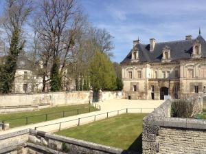 une ancienne demeure de caractère avec une clôture devant elle dans l'établissement La Virgule de Tanlay, à Tanlay