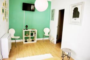 a living room with green walls and white chairs at Casa Calma Ronda in Ronda
