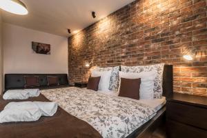 a bedroom with a brick wall and a bed at Amos Apartment - Air-Co & Private Parking Included in Košice