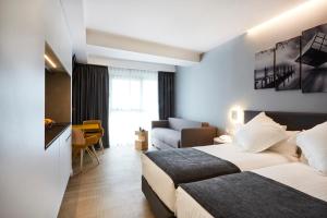 a hotel room with a bed and a couch at Sercotel Valencia Alameda 41 in Valencia