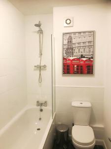 La salle de bains est pourvue de toilettes et d'une baignoire. dans l'établissement 3 Fitzhamon Embankment APARTMENTS opposite Principality Stadium - free parking nearby - LONG STAY OFFER - newly redecorated March 2024, à Cardiff