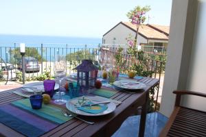 une table en bois avec des assiettes de nourriture sur un balcon dans l'établissement Destination Cefalu - your best view, à Cefalù