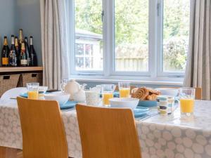 una mesa de comedor con un plato de comida y vasos de zumo de naranja en Suilven Holiday Let, en Aldeburgh
