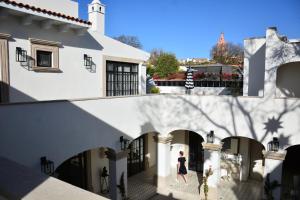 Eine Frau, die durch einen Innenhof eines weißen Hauses geht. in der Unterkunft Casa Laní Luxury B&B in San Miguel de Allende
