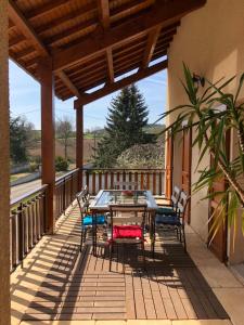 a patio with a table and chairs on a balcony at Chambres des arrys in Bas-en-Basset