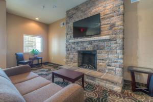 a living room with a fireplace with a flat screen tv at Cobblestone Inn & Suites - Wray in Wray
