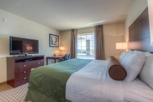 a hotel room with a large bed and a television at Cobblestone Inn & Suites - Wray in Wray