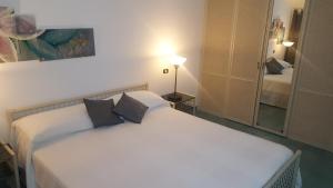 a bedroom with a white bed and a mirror at Inn Mansarda in Francavilla di Sicilia