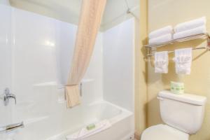 e bagno con servizi igienici, vasca e asciugamani. di Cobblestone Inn & Suites - Wray a Wray
