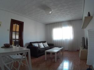 uma sala de estar com um sofá e uma mesa em MALVARROSA em Valência