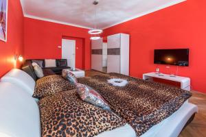 a living room with red walls and a cheetah bed at Apartman Exclusive Prague in Prague