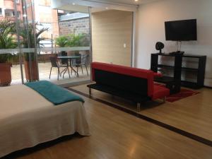 a bedroom with a bed and a couch and a table at Moderatto Suites in Medellín