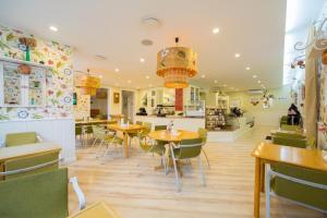 a restaurant with tables and chairs and a kitchen at Rohuaia Apartments in Rakvere