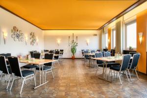 a restaurant with tables and chairs in a room at Hotel Sonne Garni in Bad Friedrichshall