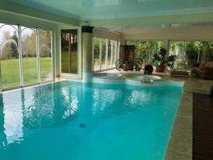 uma grande piscina com água azul numa casa em Château de Lannouan em Landévant