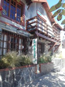 a wooden building with a sign on the side of it at La Justina Hostel in San Carlos de Bariloche