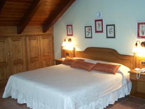ein Schlafzimmer mit einem großen weißen Bett und zwei Kissen in der Unterkunft Hotel Palazio in Nerín