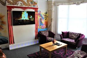 ein Wohnzimmer mit zwei Stühlen und einem Tisch in der Unterkunft Backpackers Blackpool Hotel & Suites in Blackpool