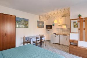 a bedroom with a table and chairs and a kitchen at Vila Milla in Premantura
