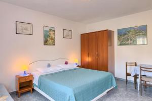 a bedroom with a blue bed and a table at Vila Milla in Premantura
