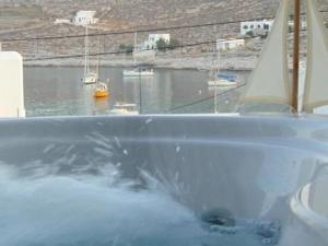 a bath tub with a view of a harbor with boats at AMO Folegandros in Karavostasi
