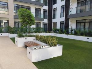 un jardin avec un banc devant un bâtiment dans l'établissement Embassy Gardens Studio, à Accra