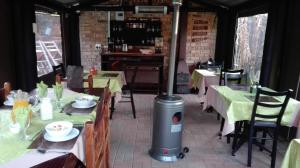 a restaurant with tables and a heater in the middle at Ukarimu Guest House in Klerksdorp