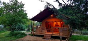 Una pequeña casa con una cortina roja. en Analaya, en Vias