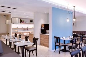un ristorante con tavoli e sedie e una cucina di Hotel Al Sole Bardolino a Bardolino
