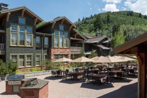 um grande edifício com mesas e guarda-sóis em frente em Lodges at Deer Valley em Park City