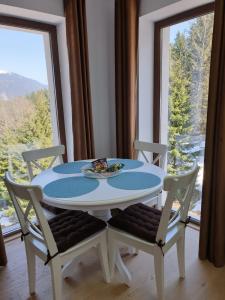 a white table and chairs with a table and a window at Nature House Predeal in Predeal