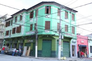 un edificio colorido en una calle con gente de pie fuera en Hotel Hot Brás, en São Paulo