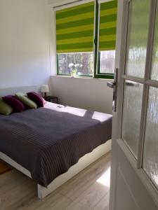 a bedroom with a bed and two windows with green blinds at Willa bankietowa z basenem in Papiernia +38 photos