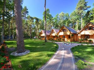 a log cabin with a walkway in a park at Bajkowe Domki in Pobierowo