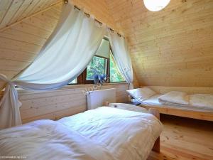 a bedroom with two beds in a wooden cabin at Bajkowe Domki in Pobierowo