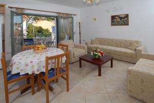 a living room with a table and a couch at Starvillas Apartments and Studios in Ayia Evfimia
