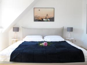 Una cama con una manta azul y flores. en Hygge Apartments Bonn en Bonn