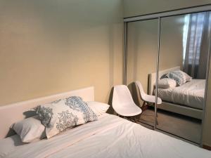 een slaapkamer met een spiegel, een bed en een stoel bij Gladiolas 1209 in Ponce