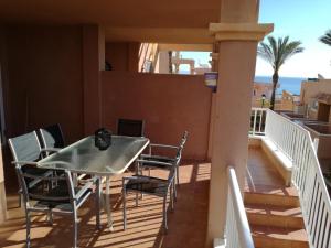 balcón con mesa, sillas y vistas al océano en Appartement Mojacar Playa Marina de la Torre, en Mojácar