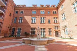a large brick building with a fountain in front of a building at Appartement le Terracotta - Parking - Place du Capitole in Toulouse