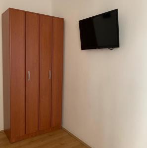 a flat screen tv on a wall next to a cabinet at Guesthouse Orlović in Budva
